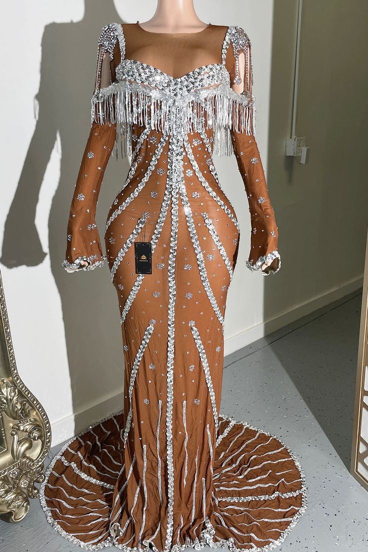 a mannequin dressed in an orange and white dress with fringes on it