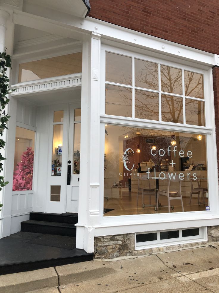 a store front with the words coffee and flowers written on it's glass window