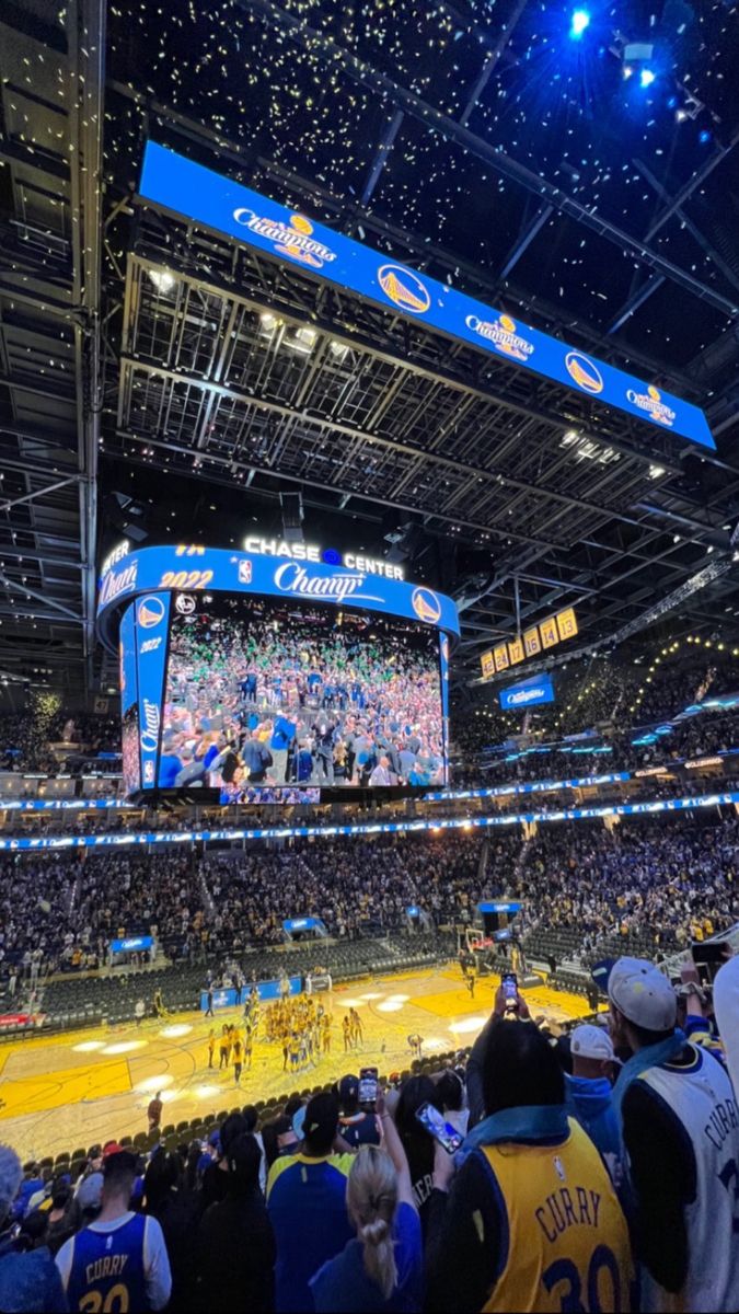 an indoor basketball game is being played on the big screen in the center of the arena