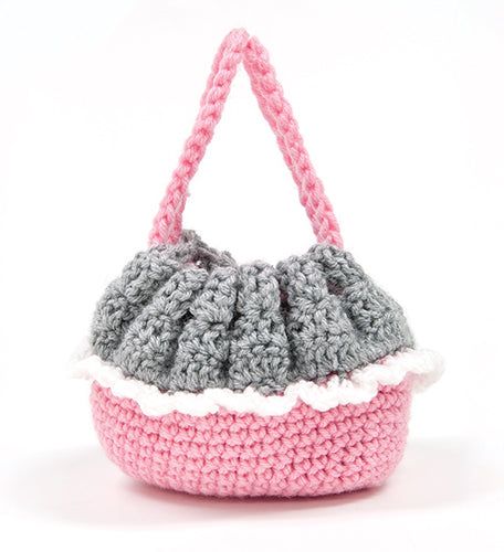 a crocheted purse with a pink handle