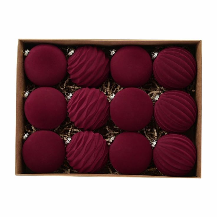 twelve red macaroons in a cardboard box