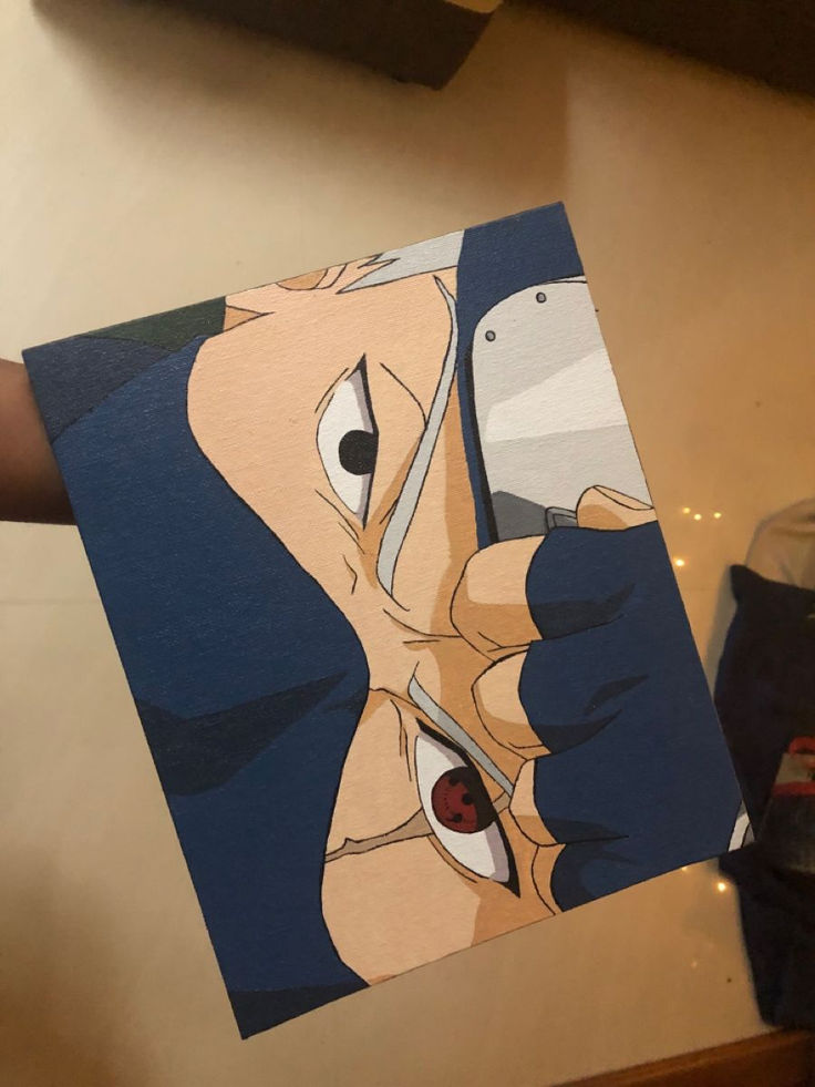 a person holding up a paper cut out of an anime character's face and eyes