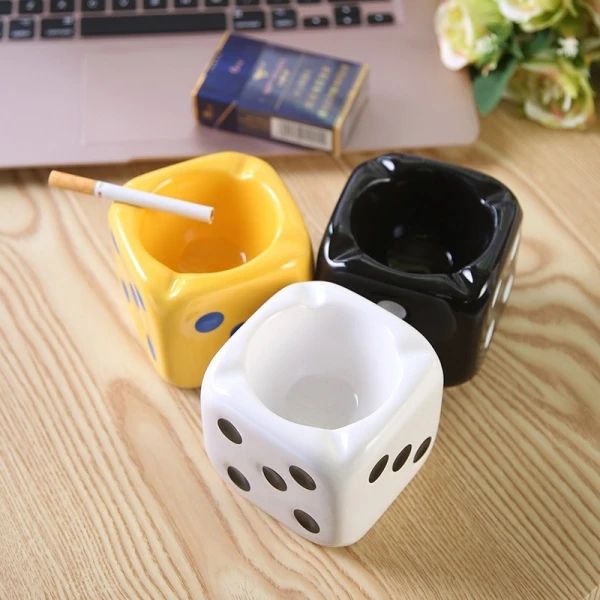 two dice shaped mugs sitting on top of a wooden table next to a laptop