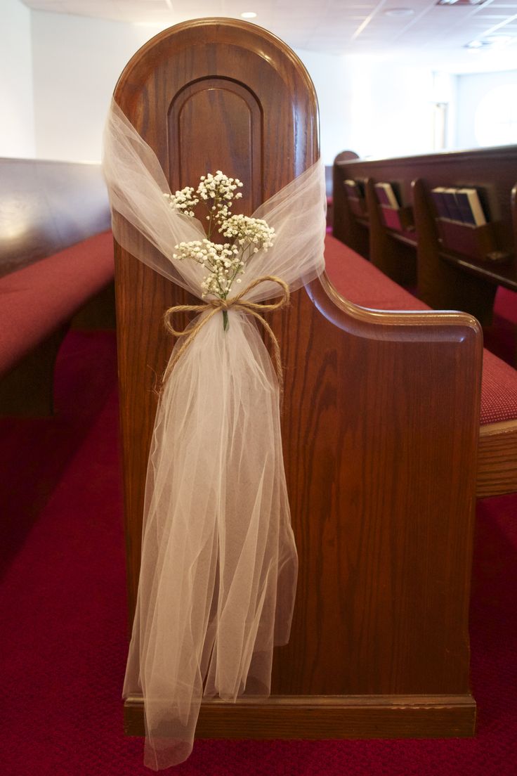 a church pew decorated with baby's breath flowers and organe bow for the aisle