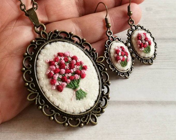 three necklaces with flowers on them sitting on a table