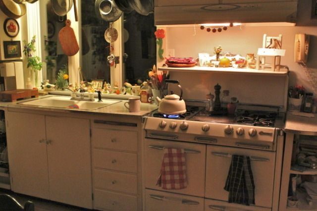 a kitchen with many pots and pans hanging from the ceiling