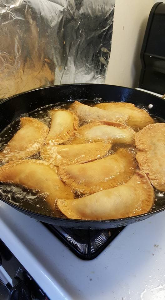 fried food cooking in a skillet on top of a stove burner with foil covering it