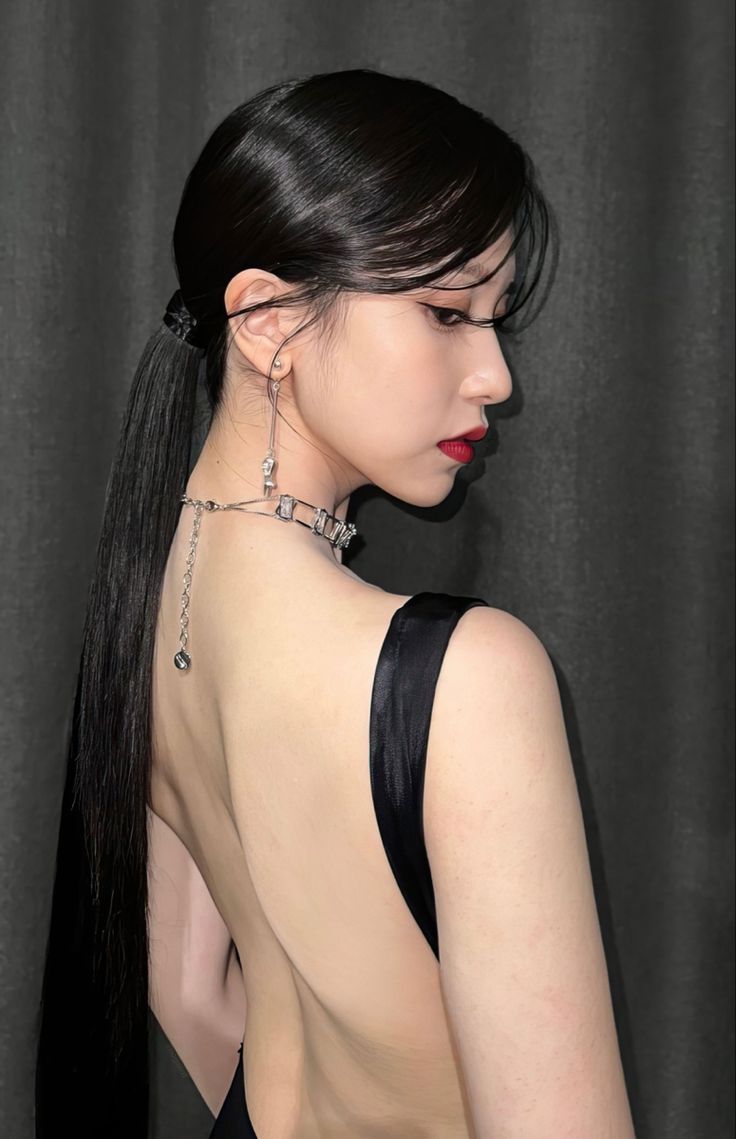 a woman with very long black hair wearing a halter top