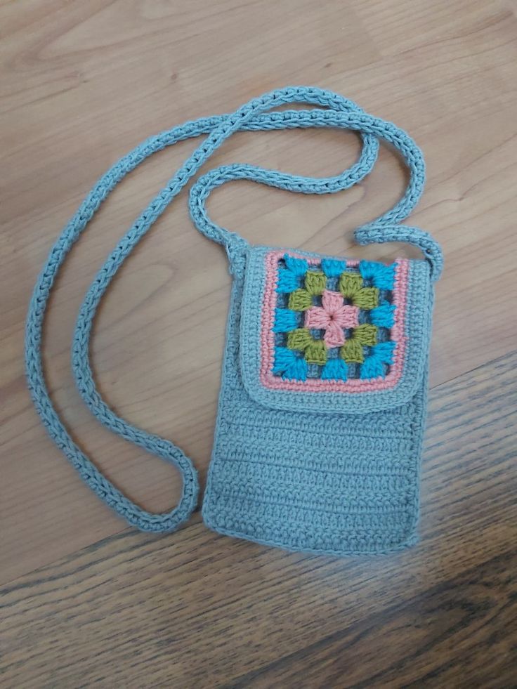 a crocheted purse sitting on top of a wooden floor