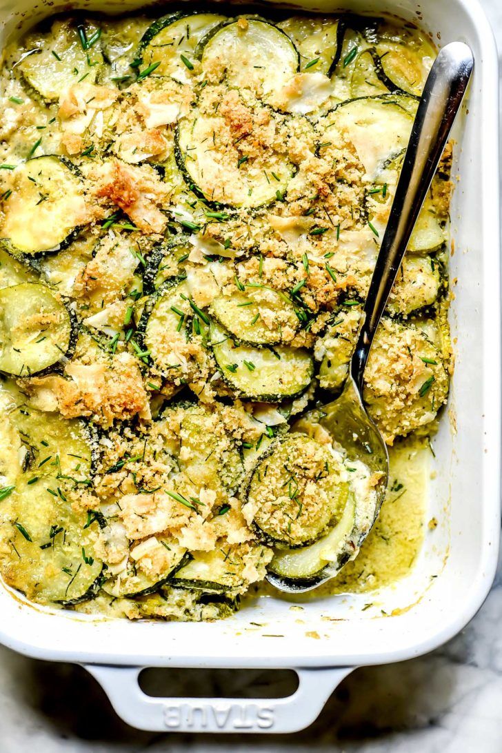 a casserole dish with zucchini and parmesan cheese