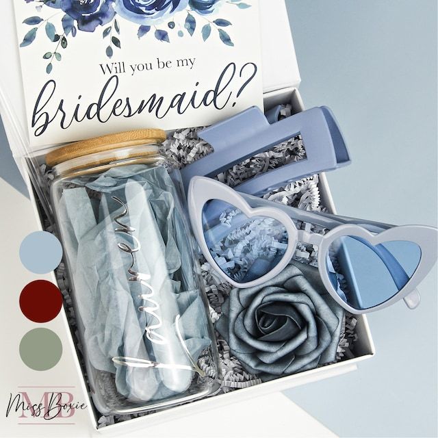 the bridesmaid gift box is filled with blue flowers and accessories for her special day