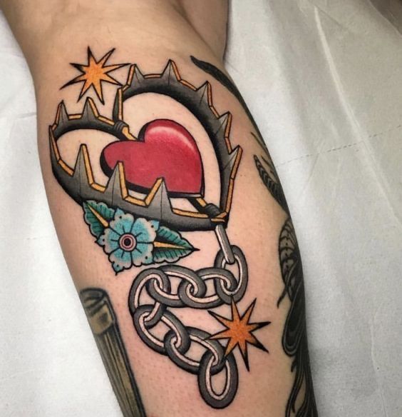 a tattoo on the arm of a person with an arrow and heart surrounded by stars