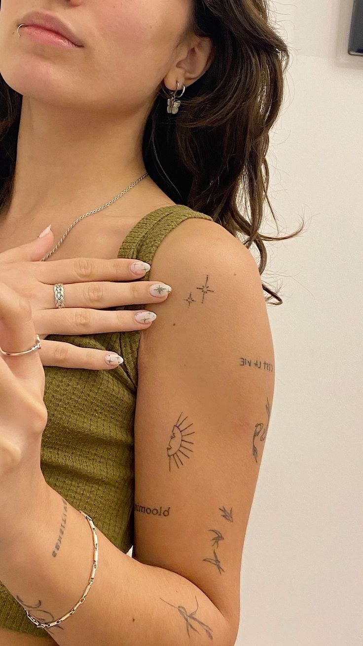 a woman with tattoos on her arm holding a cell phone