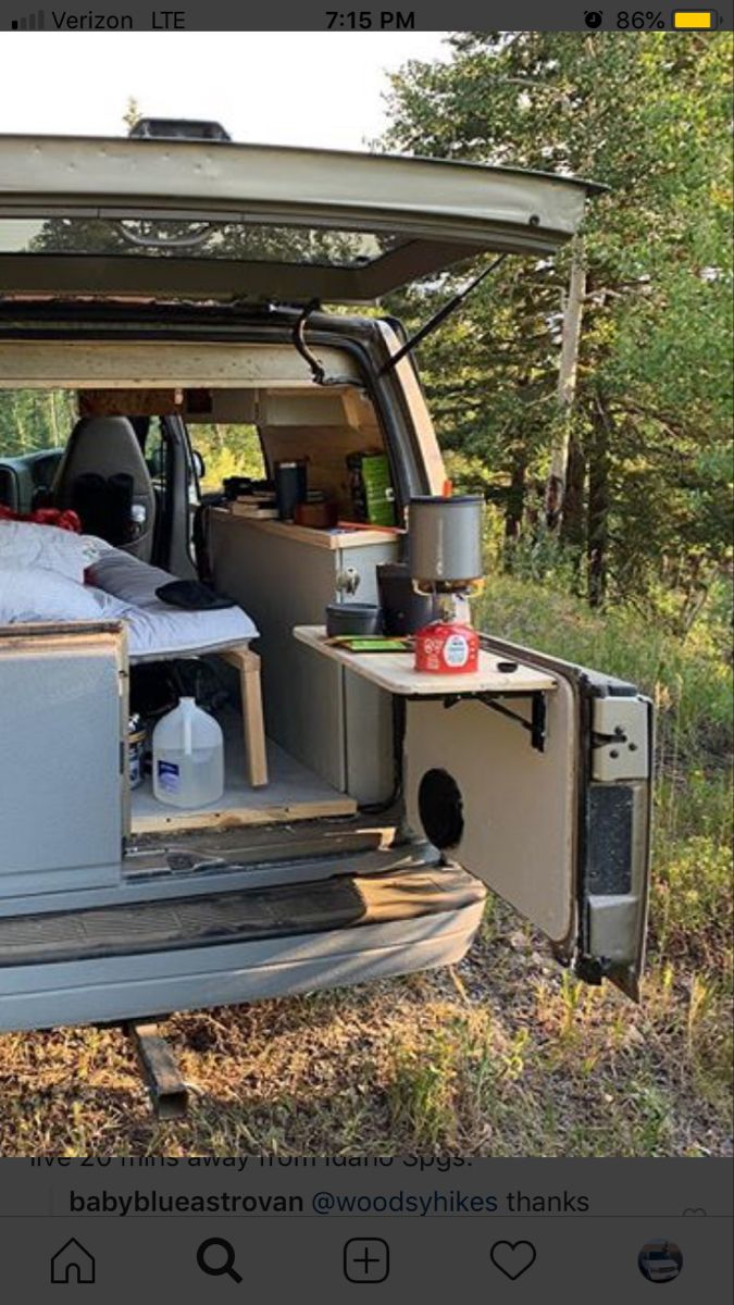 an image of the back of a van with its door open and bed in it