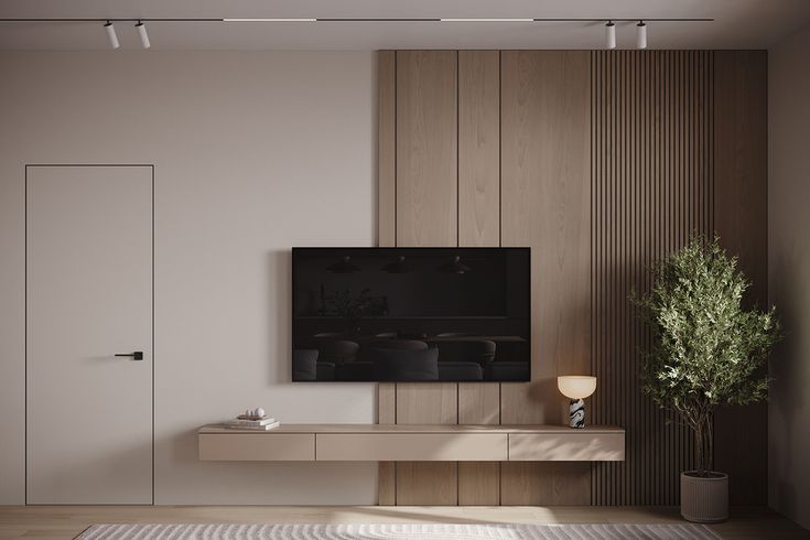 a living room with a large flat screen tv mounted on the wall next to a potted plant