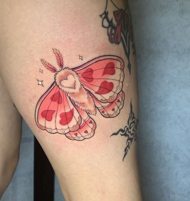 a close up of a person's leg with a butterfly tattoo on the thigh