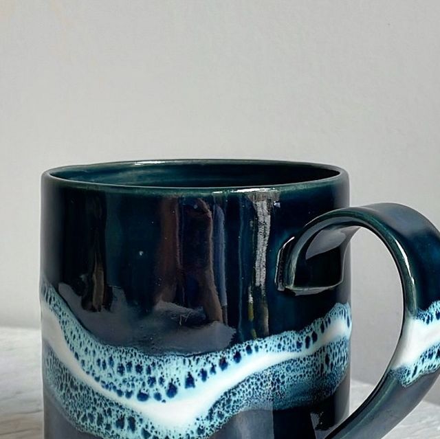 a blue and white coffee cup sitting on top of a table