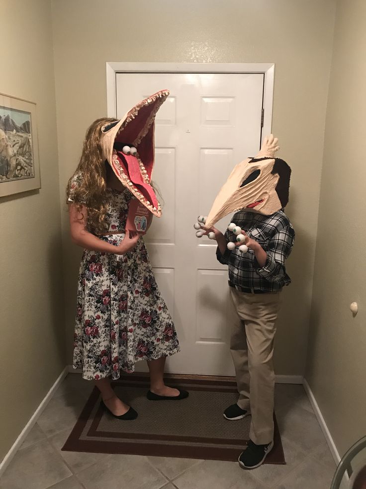 two children are standing in front of the door with masks on their faces and mouths