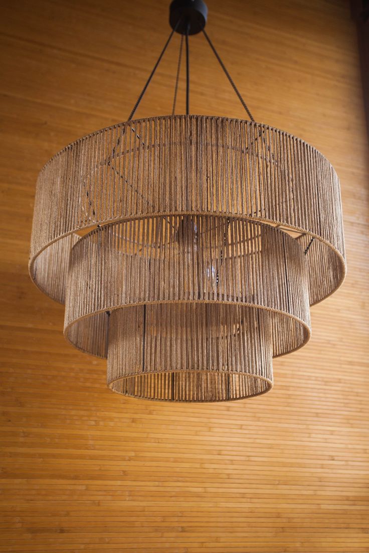 a bamboo chandelier hanging from the ceiling in a room with wood paneling