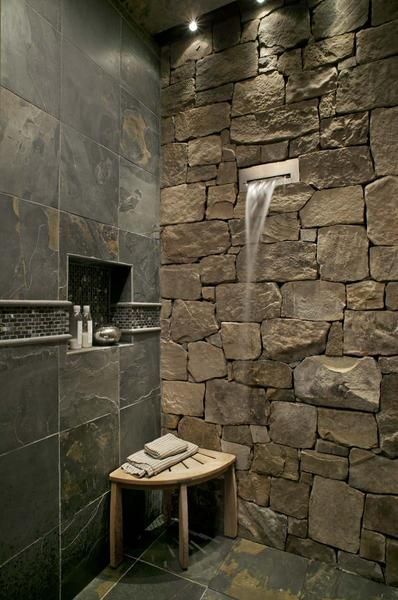 a stone shower with a waterfall coming out of it