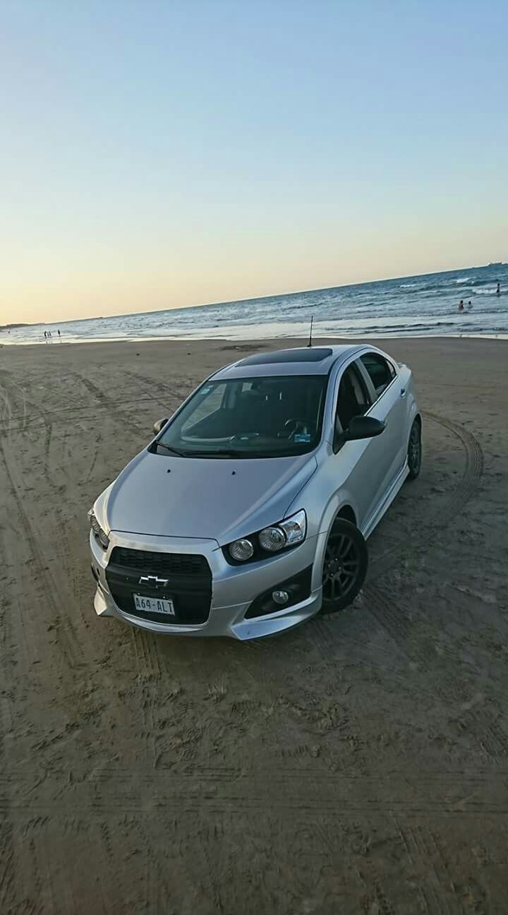 a silver car parked on top of a sandy beach