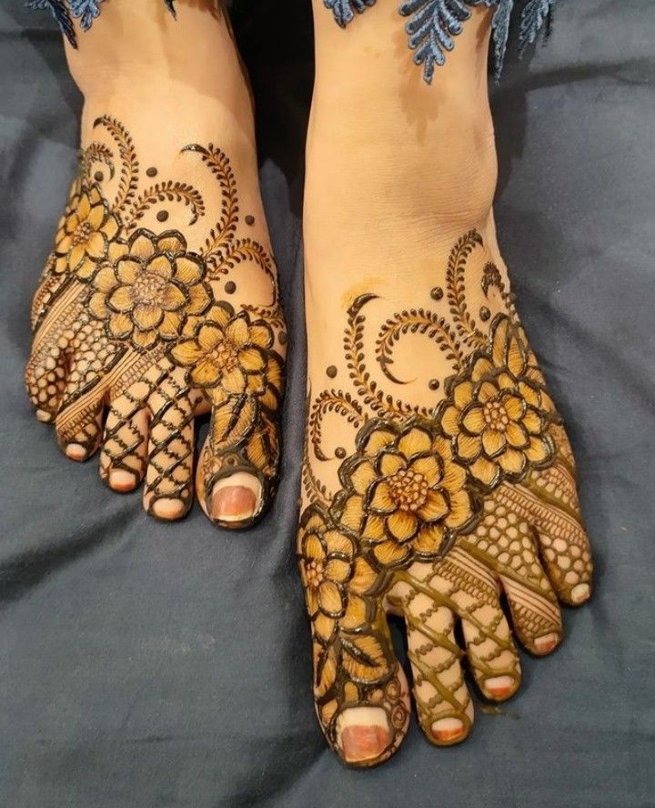 two feet with henna tattoos on them