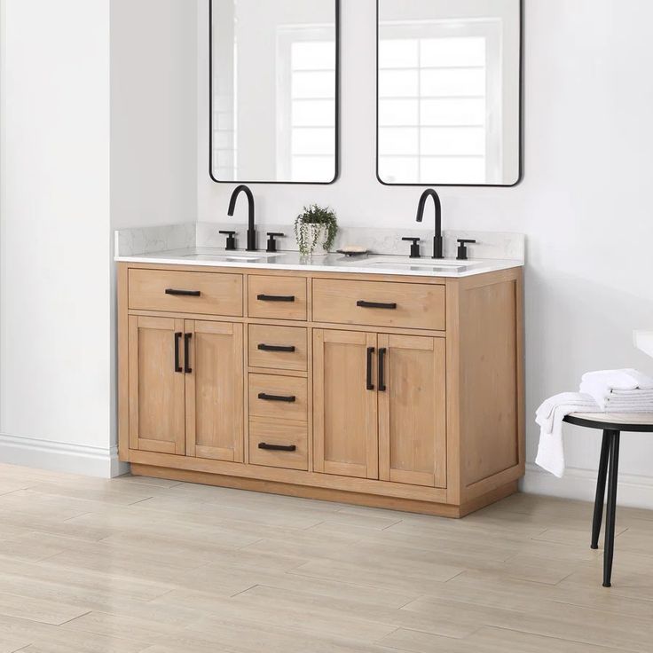 a bathroom with two sinks and mirrors on the wall