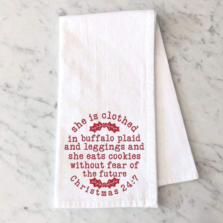 two white tea towels with the words, this is clothed in buffalo plaid and leggings and she eats cookies without fear