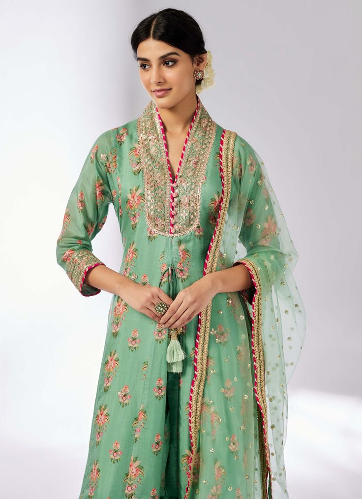 Elevate your style with this delicately embroidered ensemble that adds shimmer and richness. The long-sleeved, front-open kurta in luxurious cotton silk pairs beautifully with linen satin palazzo pants and a sheer net dupatta. Easy to carry and perfect for any occasion, this set effortlessly blends elegance with versatility. Green Chanderi Palazzo Set With Chikankari Embroidery, Green Palazzo Set With Straight Kurta And Resham Embroidery, Green Palazzo Set With Zari Work And Straight Kurta, Embroidered Floor-length Green Palazzo Set, Designer Green Embroidered Pant Set, Designer Embroidered Green Pant Set, Green Anarkali Style Cotton Silk Sharara, Green Anarkali Sharara In Cotton Silk, Green Cotton Silk Kurta With Sheer Dupatta