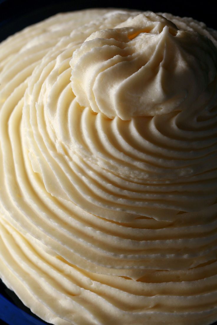 a blue plate topped with white frosting on top of a table