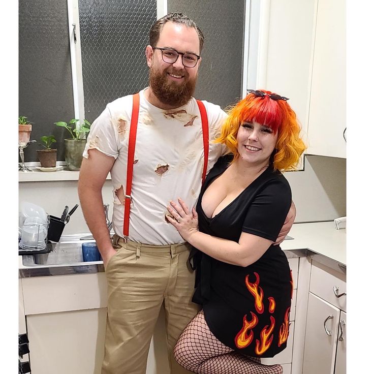 a man and woman dressed up in costumes posing for a photo with fire on their body