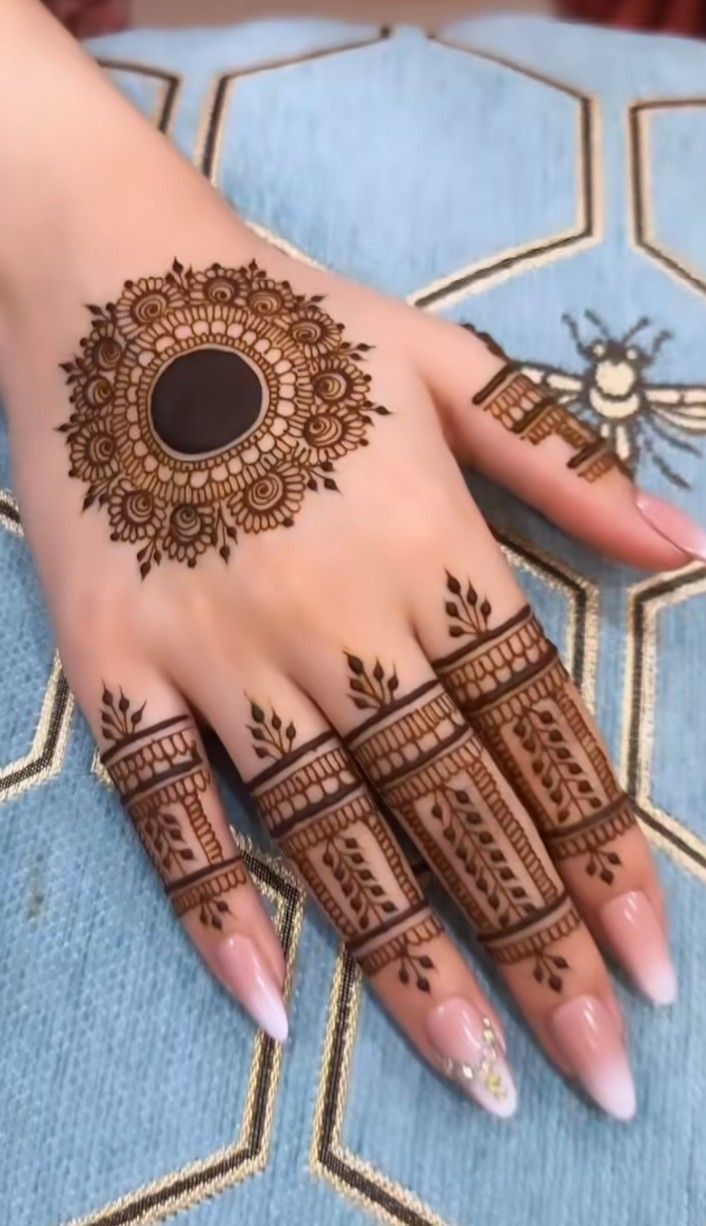 a woman's hand with henna tattoos on it