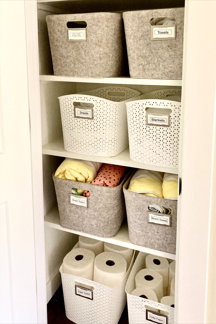 an organized closet with baskets and toilet paper