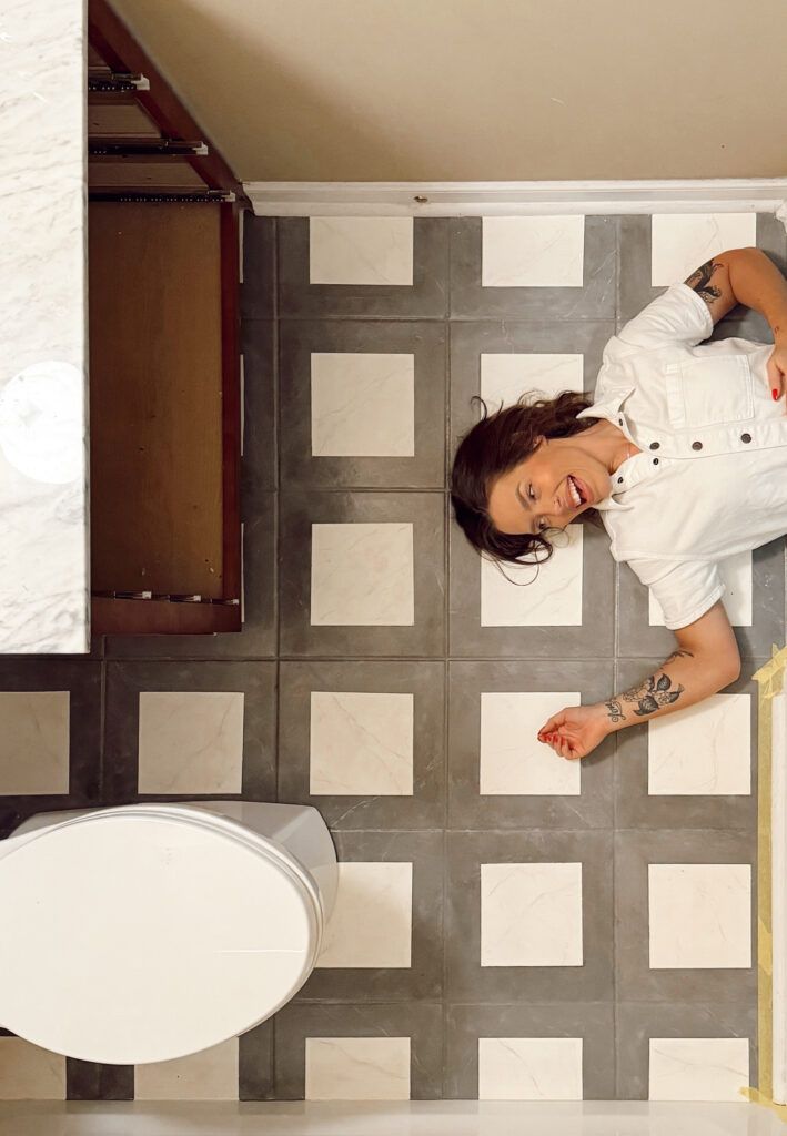 a woman laying on the floor in a bathroom