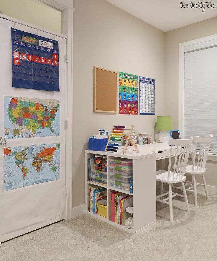 a white desk and chairs in a room with a map on the wall behind it