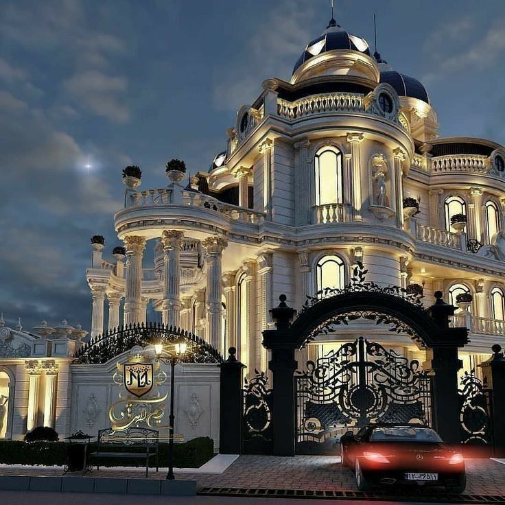 a car is parked in front of a large building with lights on it's sides