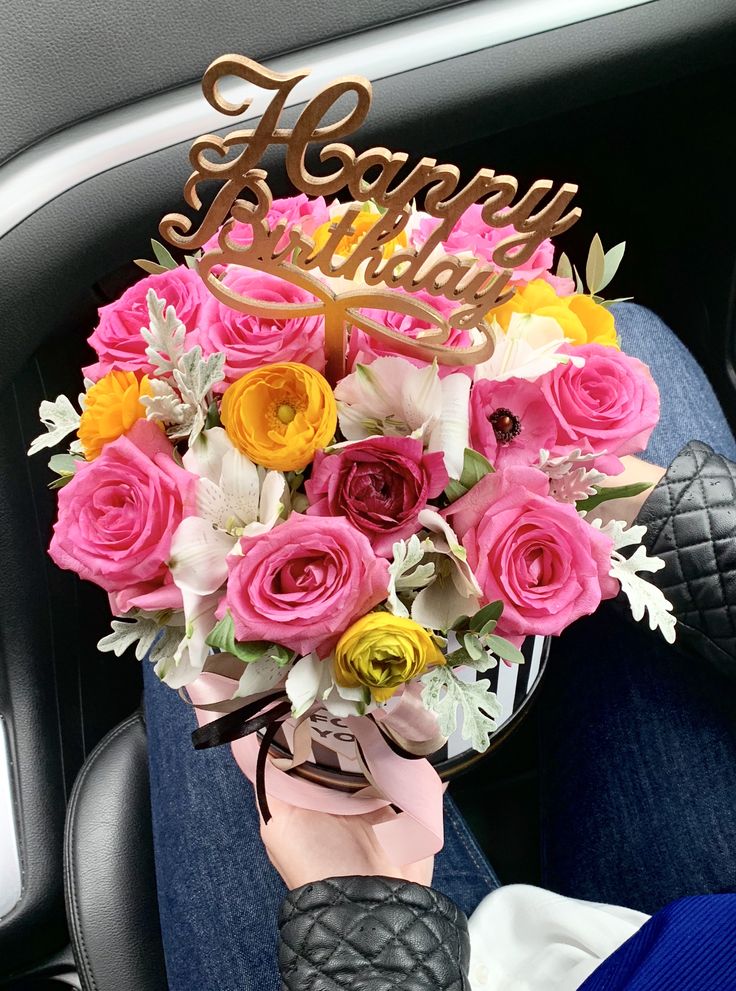 a person holding a bouquet of flowers in their hand with the words happy birthday written on it