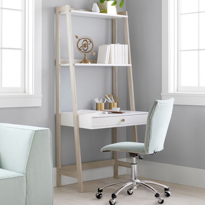 a white desk chair sitting in front of a book shelf next to a blue chair