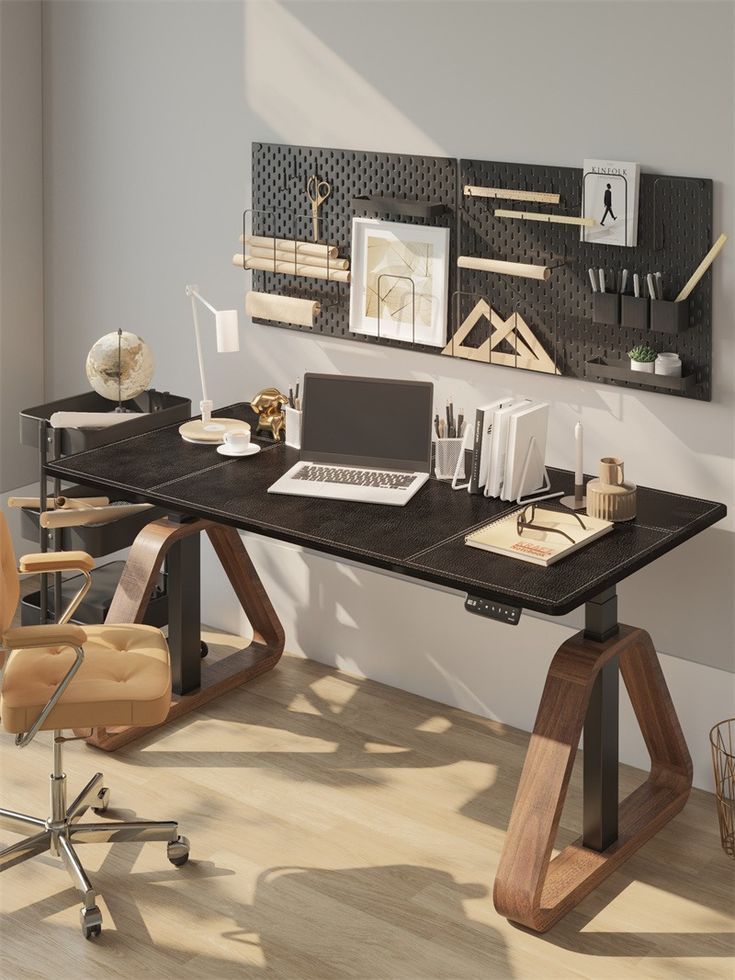 a computer desk with a laptop on top of it in front of a wall mounted art piece