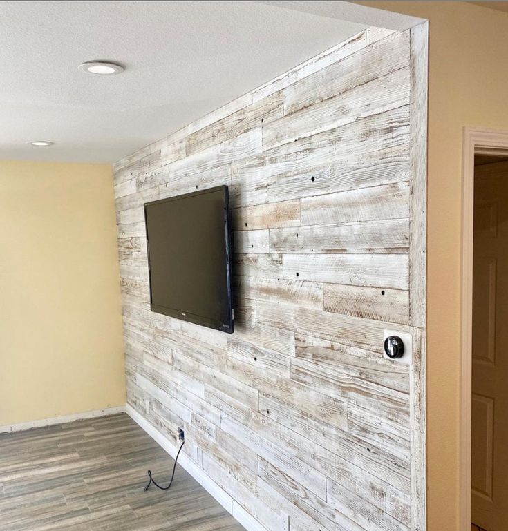 a flat screen tv mounted to the side of a wooden wall