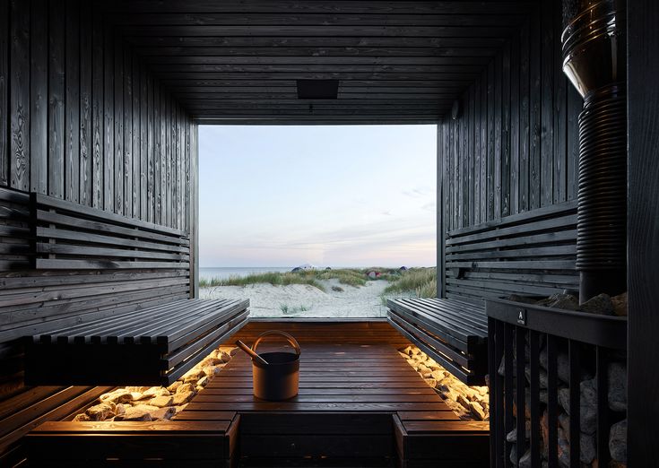 the inside of a wooden building with benches and buckets on it's side