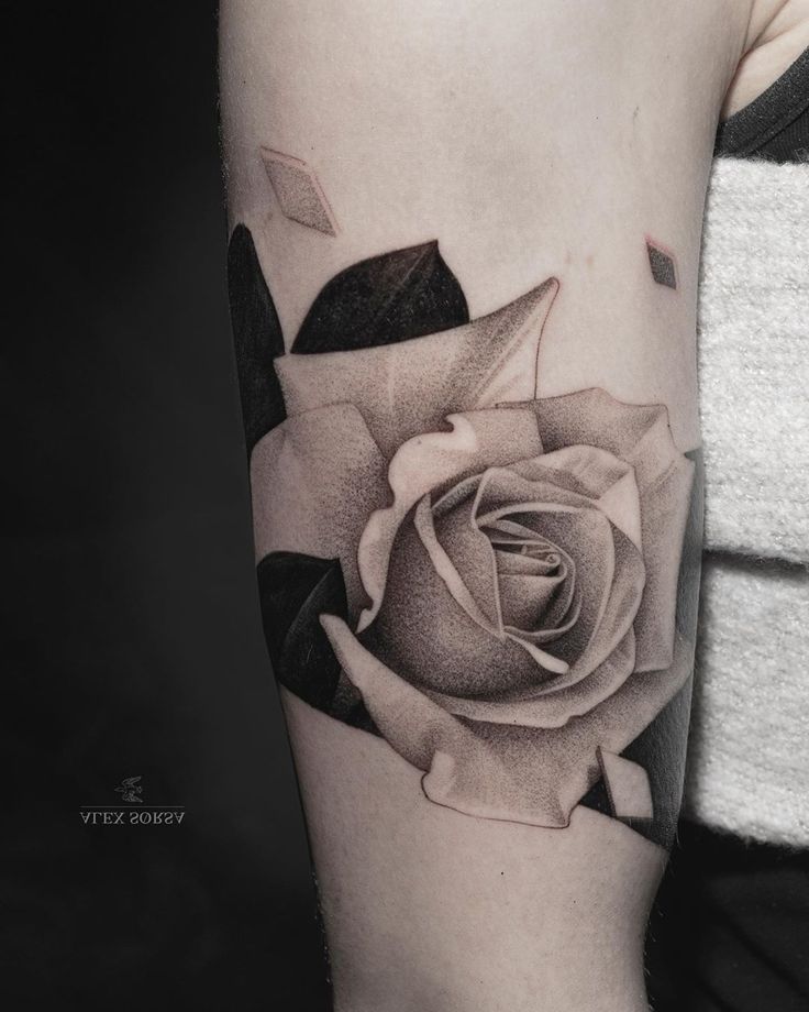 a black and white rose tattoo on the arm