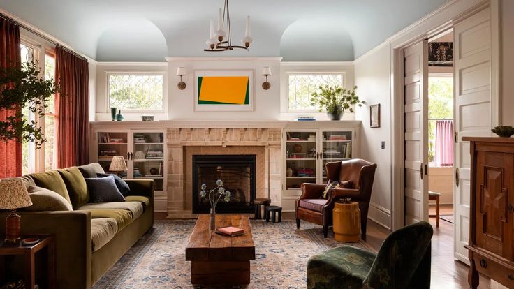 a living room filled with furniture and a fire place in the middle of a room