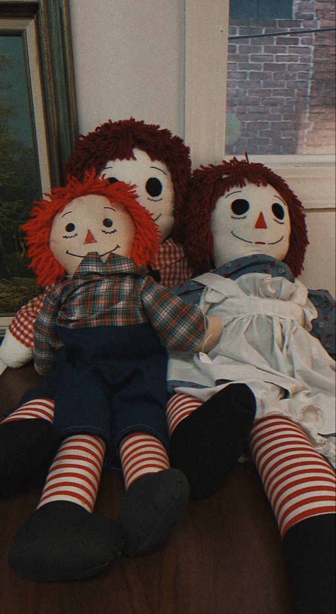 two ragged dolls sitting next to each other