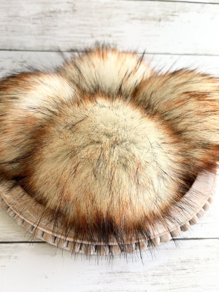 an animal fur hat sitting on top of a wooden table