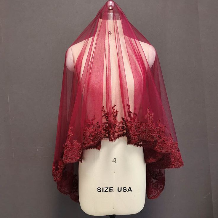 a mannequin wearing a red cape with lace on the top and bottom part