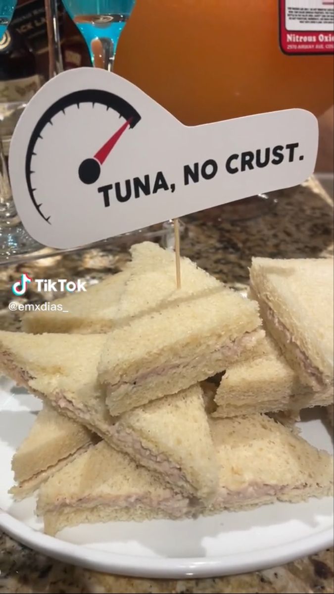 tuna, no crust sandwich cut in half on a plate with a speedometer sign