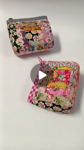 two small wallets are sitting next to each other on a white surface and one has a patchwork design