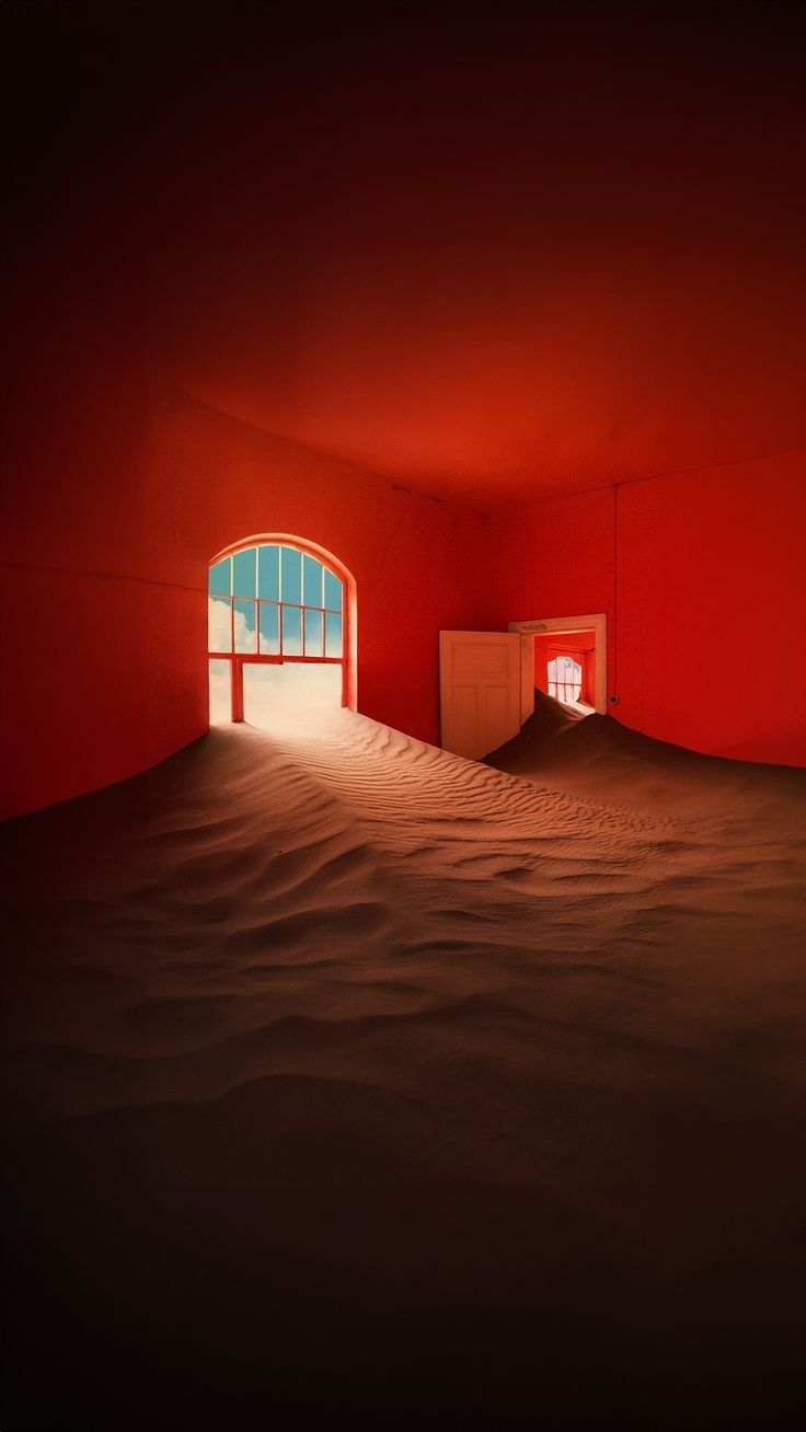 an empty room with red walls and a window in the middle that looks like sand dunes