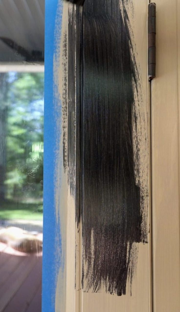 black paint is being applied on the side of a door